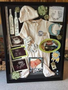 a baby's birth gift is displayed in a shadow box with pictures and other items