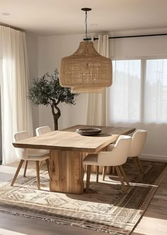 a dining room table with chairs and a potted tree in the middle of it