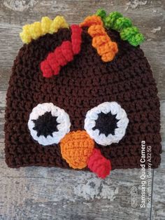 a crocheted turkey hat on top of a wooden table