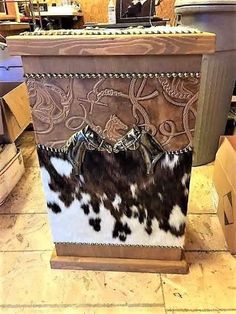 a cowhide covered box sitting on top of a tiled floor