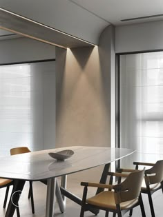 a dining room table with chairs and a bowl on the table in front of it