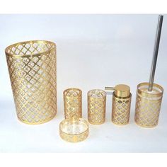 an assortment of gold bathroom accessories including toothbrush holder, soap dispenser and tumbler