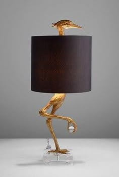 a lamp that is shaped like a bird with a black shade on it's head