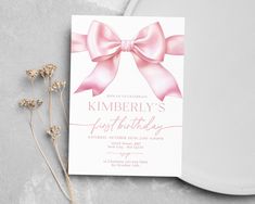 a pink bow birthday party card on a plate with some dried flowers next to it