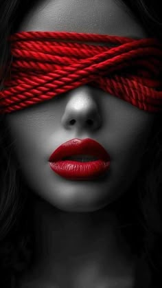 a woman with red lipstick tied up to her face and blind folded over her eyes