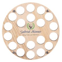 a wooden golf ball marker with holes in the center and an inscription on it that says gabril skinner keep calm and well