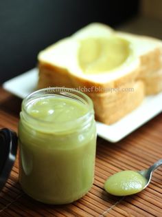 there is a jar of green liquid next to some slices of bread