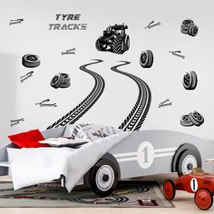 a child's bedroom with a toy car and track wall decals on the walls