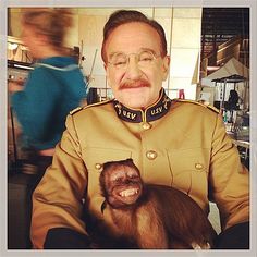 a man in uniform is holding a monkey