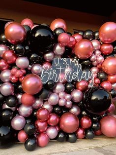 a bunch of balloons that say it's my birthday on the side of a building