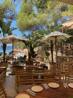 an outdoor dining area with wooden tables and umbrellas