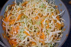 shredded carrots and cabbage in a bowl with a spoon