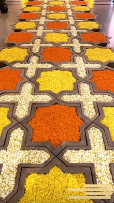 the floor is covered with many different colored grains and flowers, all arranged in an intricate pattern