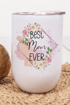 a white coffee mug with the words best mom ever on it next to a nut