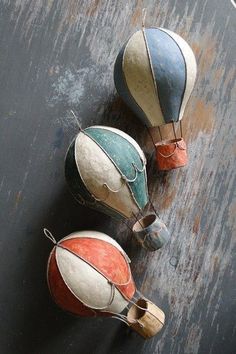 three colorfully painted pots sitting on top of a wooden table