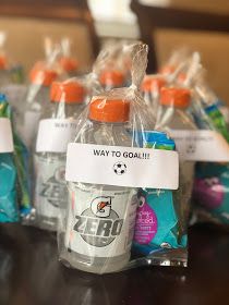 several bottles of water sitting on top of a table next to plastic bags with orange caps