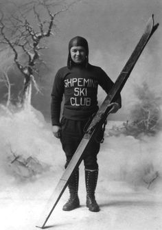 an old black and white photo of a man holding skis