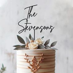 a wedding cake with flowers and leaves on top that says the stevensons in cursive writing