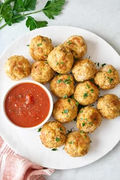 a white plate topped with meatballs and dipping sauce