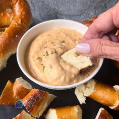 a person dipping some bread into a bowl