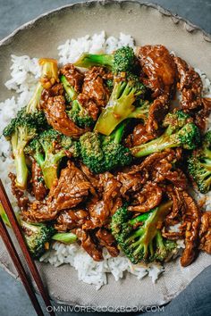 beef and broccoli served over rice with chopsticks