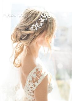 the back of a woman's head wearing a bridal hair piece with flowers in it