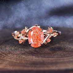 an orange diamond ring sitting on top of a wooden table