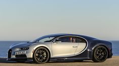 a bugatti car parked on the beach next to the ocean