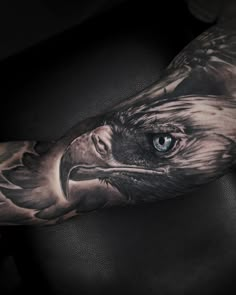 an eagle tattoo on the arm with blue eyes