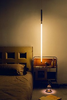 a bed sitting next to a lamp on top of a table