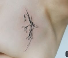 a woman's breast with a flower tattoo on her left side ribcage