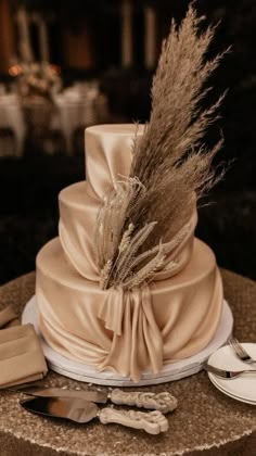 a three tiered wedding cake on top of a table with utensils and napkins