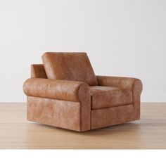 a brown leather chair sitting on top of a hard wood floor