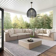 a living room filled with furniture on top of a hard wood flooring covered porch