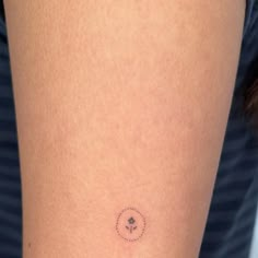 a woman with a small tattoo on her arm that has an arrow in the center