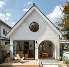 a white house with an open patio and wooden steps leading up to the front door