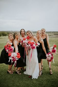 a group of women standing next to each other holding bouquets