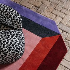 a multicolored rug on the ground with an odd shaped object in front of it