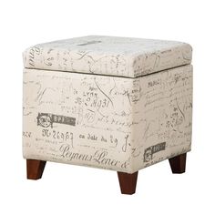 an upholstered storage ottoman with writing on the top and legs, in white