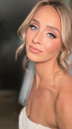 a woman with blonde hair and blue eyes wearing a white dress is posing for the camera