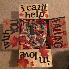 a box filled with candy sitting on top of a floor next to a sign that says i can't help