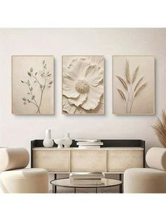 three paintings on the wall in a living room