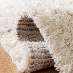 a close up of a rug on the floor with a wooden floor in the background