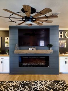 a living room with a ceiling fan and a flat screen tv mounted on the wall