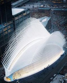 an aerial view of a large white building in the middle of a city at night