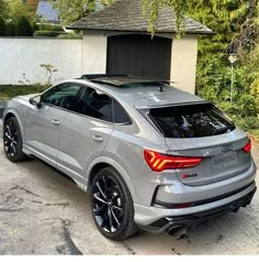 an audi suv parked in front of a house