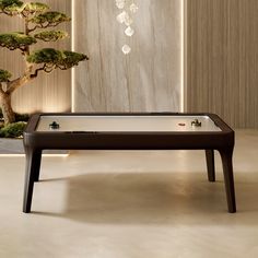 a pool table in front of a bonsai tree with lights hanging from the ceiling