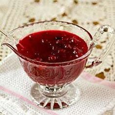 a glass bowl filled with red liquid on top of a white doily covered table