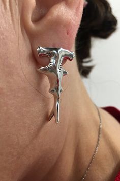 a close up of a person wearing some kind of silver earring on their neck