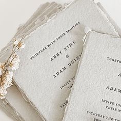 four wedding cards with flowers on them sitting next to each other, all in white paper